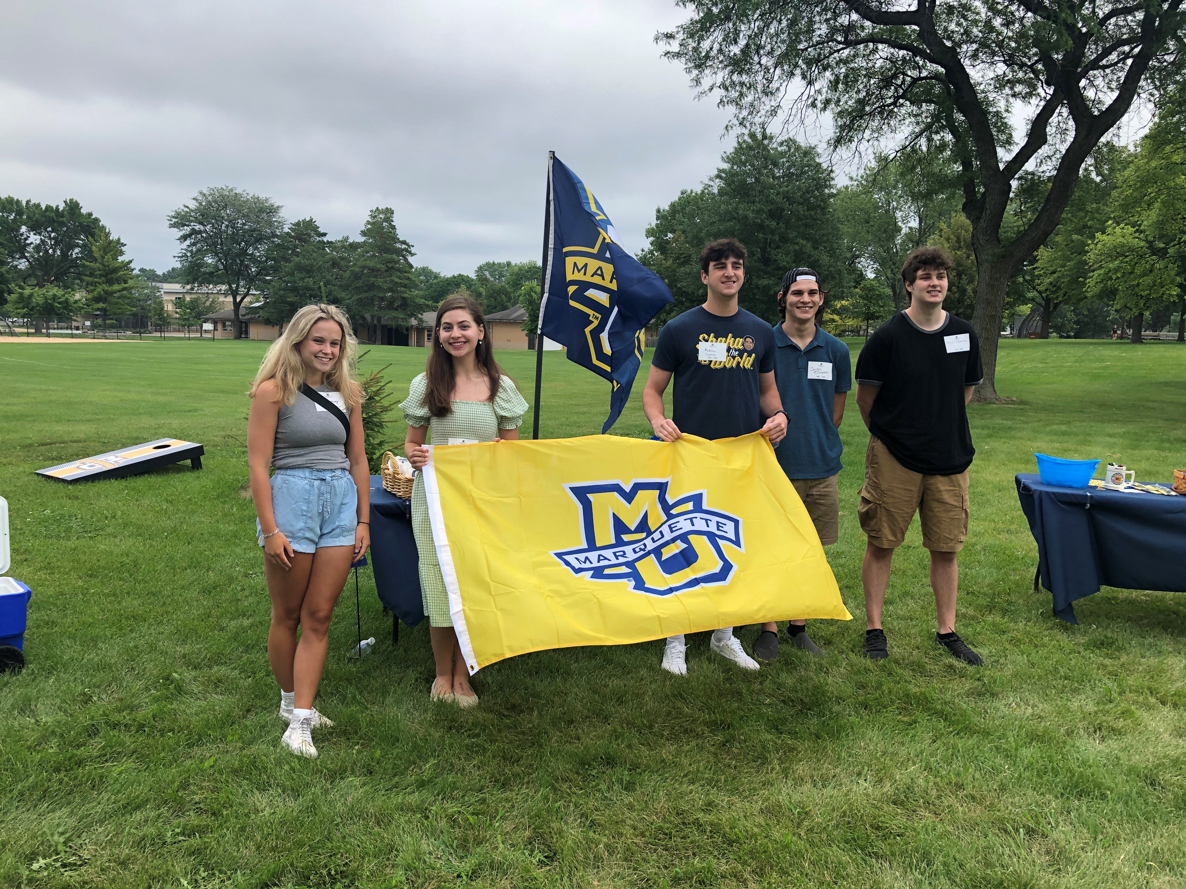 Group of students holding Marquette flag outside